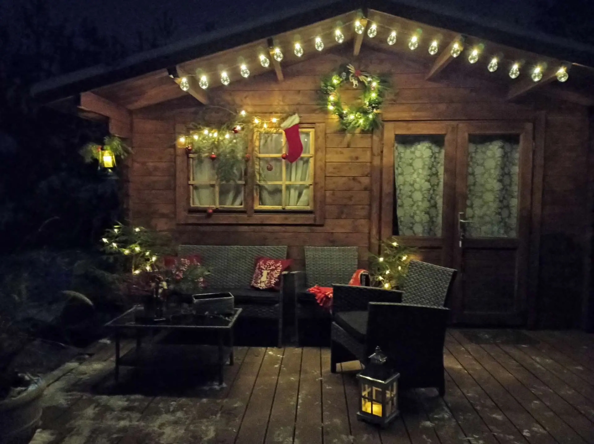 Trobelė vakare su lempučių girlianda ir vainiku